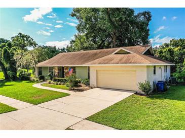 Charming single-story home features a well-manicured lawn, attached garage, and inviting curb appeal at 2223 Wildwood Hollow Dr, Valrico, FL 33596