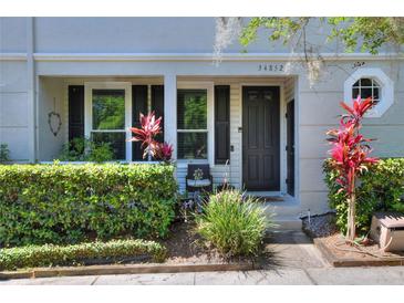 Charming front entrance with lush landscaping and a cozy seating area at 34852 Teeview Ln, Zephyrhills, FL 33541