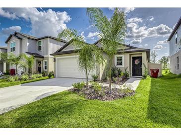 Charming single-Gathering home with a well-manicured lawn, two-car garage and beautiful landscaping at 4035 Radiant Mountain Dr, Plant City, FL 33565