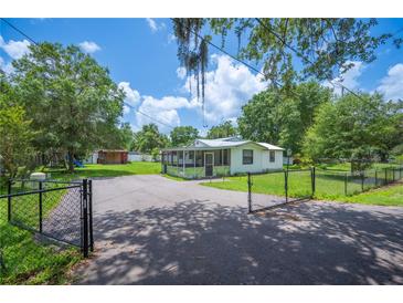 Scenic property featuring a gated driveway, lush greenery, and a cozy home perfect for outdoor enjoyment at 3611 Maxwell Rd, Plant City, FL 33566