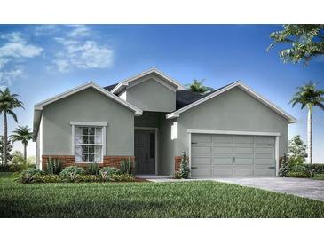 Charming single-story home featuring a gray exterior, landscaped yard, and a two-car garage at 35392 Coventry Fields Loop, Zephyrhills, FL 33541