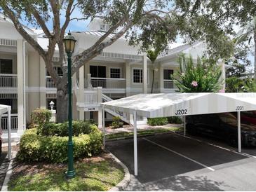 Inviting condo exterior with covered parking and lush landscaping in a well-maintained community at 3608 54Th W Dr # 202, Bradenton, FL 34210