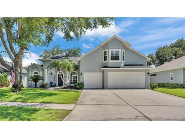 Charming home with a three-car garage, manicured lawn, and beautiful landscaping at 3911 Smoke Rise Ct, Valrico, FL 33594