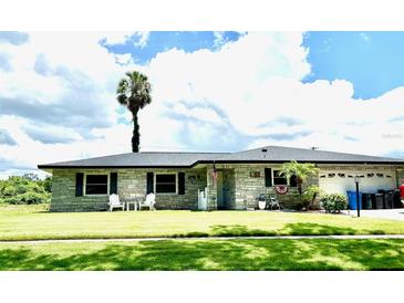 Charming single story home with a lush green lawn and a beautiful palm tree in the front yard at 704 Queens Ct, Seffner, FL 33584