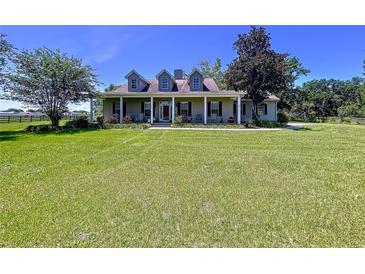 Spacious two-story home with a large front yard and covered porch, perfect for enjoying the outdoors at 4611 Executive Meadows Dr, Plant City, FL 33567