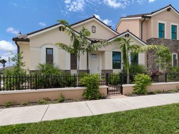 Tan house with brown roof, black fence, and palm trees in front at 938 E Venice Ave, Venice, FL 34285
