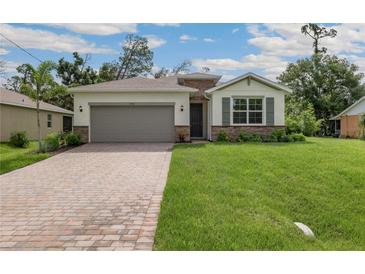 New construction home with a brick facade and a large driveway at 1508 Atwater Dr, North Port, FL 34288