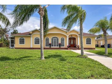 House exterior with palm trees and manicured lawn at 12209 Cotorro Ave, North Port, FL 34287