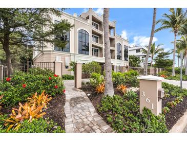 Elegant multi-story home with lush landscaping, featuring a paved walkway and a beautifully maintained garden at 361 Benjamin Franklin Dr # A, Sarasota, FL 34236