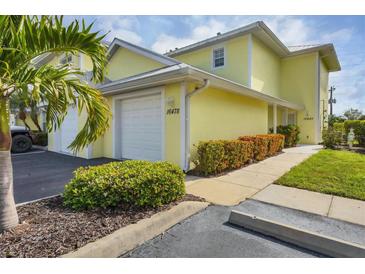 Bright yellow two-story condo with attached garage and landscaping at 16478 Gloria Ln # 208, Nokomis, FL 34275