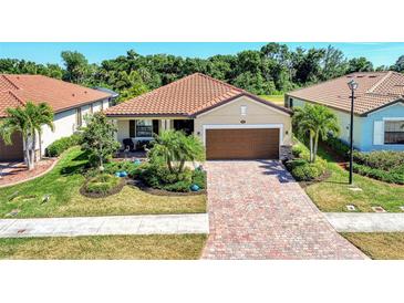 One-story home with brick driveway, landscaping, and tile roof at 12297 Canavese Ln, Venice, FL 34293
