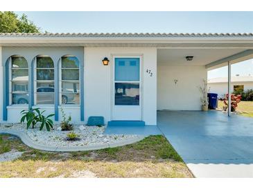 Front view of a single story home with carport and landscaped yard at 472 Circlewood Dr # L9, Venice, FL 34293