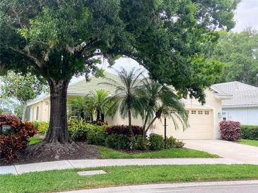 House exterior featuring a charming, light-yellow home with mature landscaping at 334 Melrose Ct, Venice, FL 34292