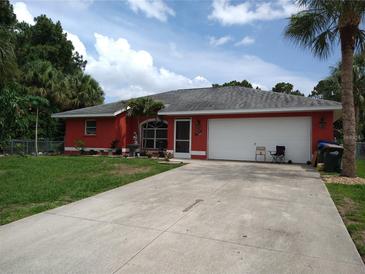 Red single-story home with attached garage and neatly landscaped yard at 3781 Wayward Ave, North Port, FL 34286