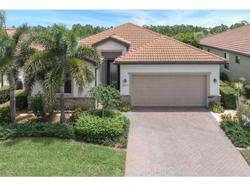 Beautiful one-story home with a two-car garage and lush landscaping at 10079 Crooked Creek Dr, Venice, FL 34293