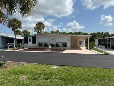 Charming single-story home with a well-maintained yard, covered parking, and mature palm trees at 209 Roma Rd, Venice, FL 34285