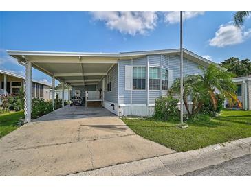 Mobile home with carport, landscaping, and a flagpole at 3405 Shingle Oak Ter, Sarasota, FL 34237