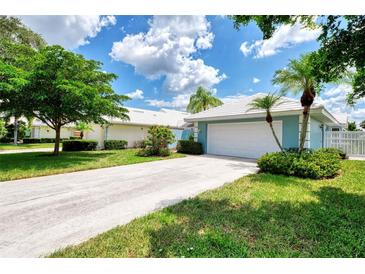 Light blue house with a white garage door and landscaped yard at 803 Harrington Lake N Dr # 75, Venice, FL 34293