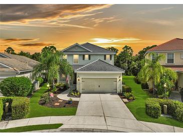 Two-story house with landscaped yard and attached garage at sunset at 12196 Alachua Ln, Venice, FL 34293