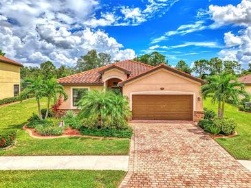 Single-story home with tile roof, landscaping and driveway at 12261 Canavese Ln, Venice, FL 34293