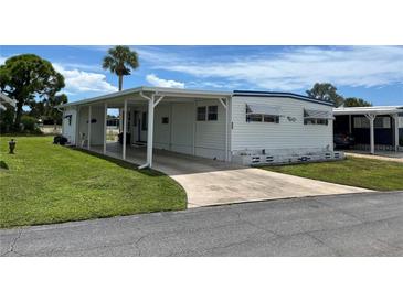 White mobile home with carport and landscaping at 200 Roma Rd, Venice, FL 34285