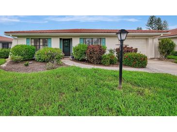 Charming ranch home with a well-manicured lawn and walkway at 5103 Greencroft Rd, Sarasota, FL 34235