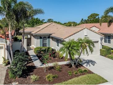 Charming single-story home featuring lush tropical landscaping, a tile roof, and a welcoming two-car garage at 277 Mestre Pl, North Venice, FL 34275