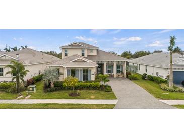 Charming two-story home with a manicured lawn and a paver driveway at 8209 Redonda Loop, Lakewood Ranch, FL 34202