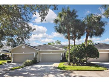 Tan house with three-car garage and palm trees at 857 Tartan Dr, Venice, FL 34293