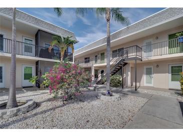 Two-story building with multiple units, balconies, and a courtyard at 612 Guild Dr # 18, Venice, FL 34285