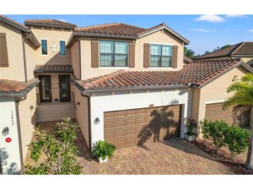 Two-story townhome with a two-car garage and brick driveway at 12460 Ghiberti Cir # 202, Venice, FL 34293