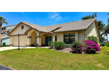 Charming single-story home featuring a tile roof, arched entryway, and a well-manicured lawn at 217 Carriage House Ln # 217, Nokomis, FL 34275