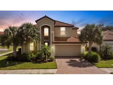 Two-story house with a red tile roof, palm trees, and a brick driveway at 19304 Bluff Dr, Venice, FL 34292