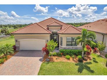 Single-story home with tile roof and landscaped yard at 25159 Spartina Dr, Venice, FL 34293