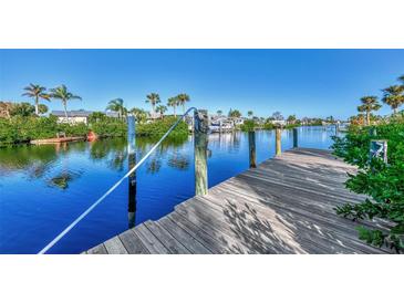 Wooden dock extending over calm water, ideal for enjoying waterfront views at 4646 Fallon Cir, Port Charlotte, FL 33948