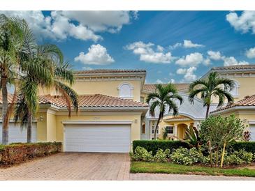 Front view of a charming two-story home with a white garage door at 1704 Triano Cir # 1704, Venice, FL 34292