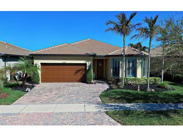 Single-story home with brown garage door and palm trees at 13848 Rinuccio St, Venice, FL 34293