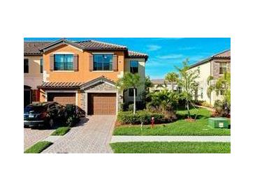 Two-story townhome with a two-car garage and well-manicured landscaping at 20391 Lagente Cir, Venice, FL 34293