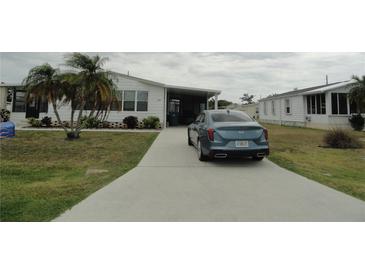 Charming single-story home with a well-maintained lawn, palm trees, and a concrete driveway at 6234 Parakeet Rd, Englewood, FL 34224