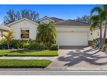 Single-story house with a two-car garage and landscaped yard at 11723 Breadfruit Ln, Venice, FL 34292