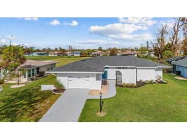 Single-story home with attached garage and well-manicured lawn at 116 Caddy Rd, Rotonda West, FL 33947