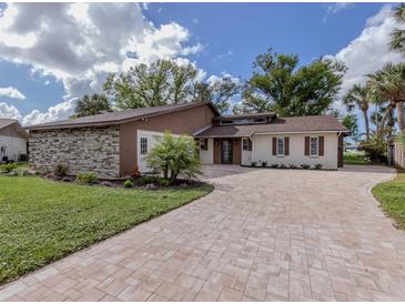Charming two-story home with a stone facade, updated landscaping, and paved driveway at 1141 Sleepy Hollow Ct, Venice, FL 34285