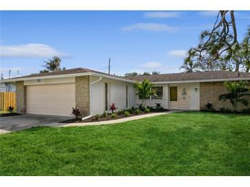 Updated ranch home with a stone facade, attached garage, and landscaped lawn at 352 Gardenia Rd, Venice, FL 34293