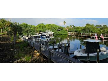 Private dock featuring lush landscaping, access to water, boat, and peaceful surroundings at 709 Sorrento Inlt # 709, Nokomis, FL 34275