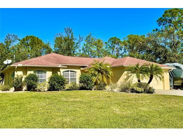 Single-story home with a red tile roof, landscaped yard, and attached garage at 7339 Cameo Cir, North Port, FL 34291