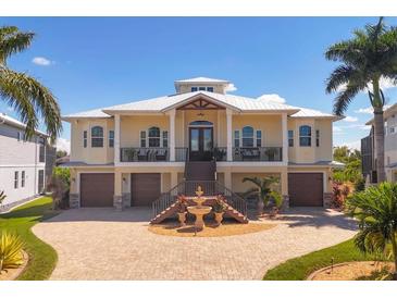 Two-story house with a double garage, fountain, and palm trees in the front yard at 8065 Weyers Ct, Englewood, FL 34224