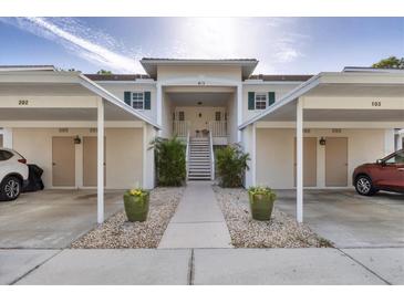 Inviting condo complex featuring covered parking, lush landscaping, and a welcoming entrance at 815 Montrose Dr # 103, Venice, FL 34293