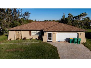 Single-story home with a brown roof, white garage door, and landscaped lawn at 4222 Cockrell St, Port Charlotte, FL 33948