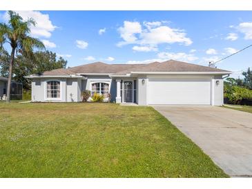 One-story home with a white exterior, attached garage, and well-maintained lawn at 4467 Cinderella Cir, North Port, FL 34286