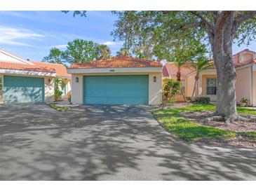 Condo with teal garage door and nicely landscaped front at 606 Marcus St # 26, Venice, FL 34285